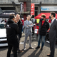 hiroshi tamura, wearing a gray tailored suit, stands in the center of a group of five men at R's Meeting, a get together for nissan gt-rs